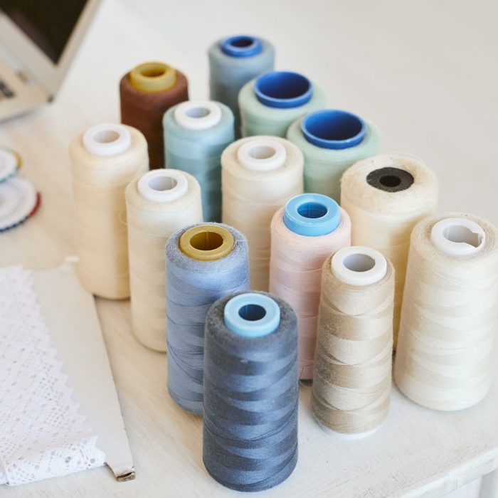 angle-eleve-de-bobines-de-fil-sur-table-avec-ordinateur-portable-en-atelier (2)
